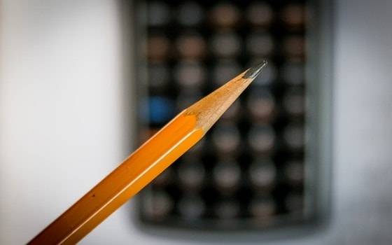 карандаш на фоне калькулятора