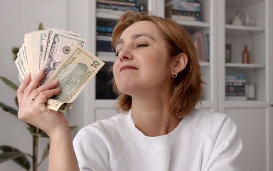 женщина смотрит на доллары